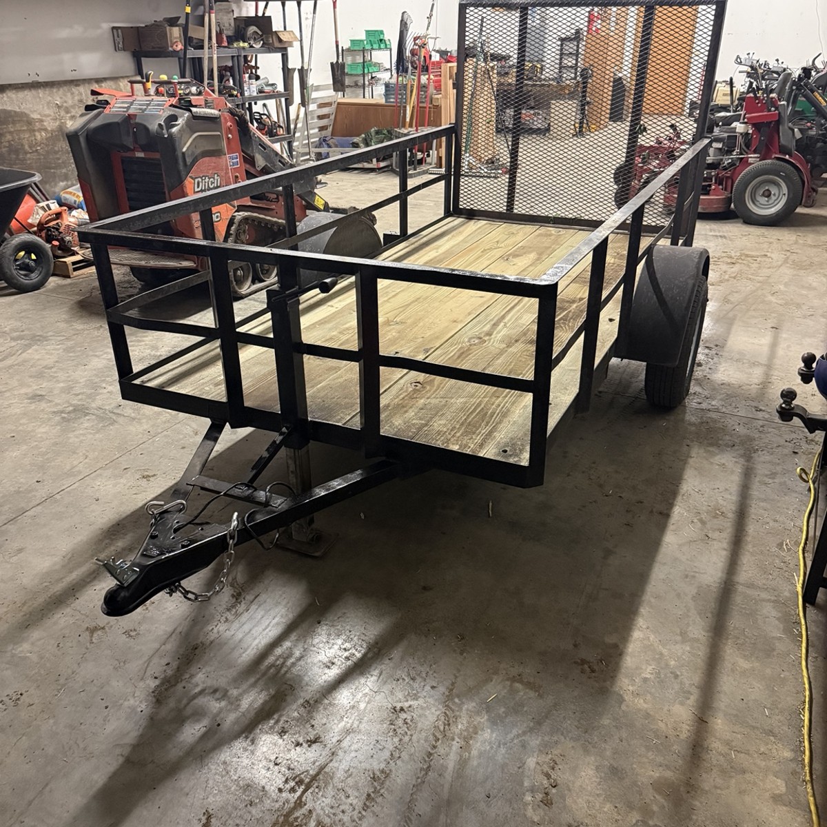Utility trailer with welded steel frame and wood deck