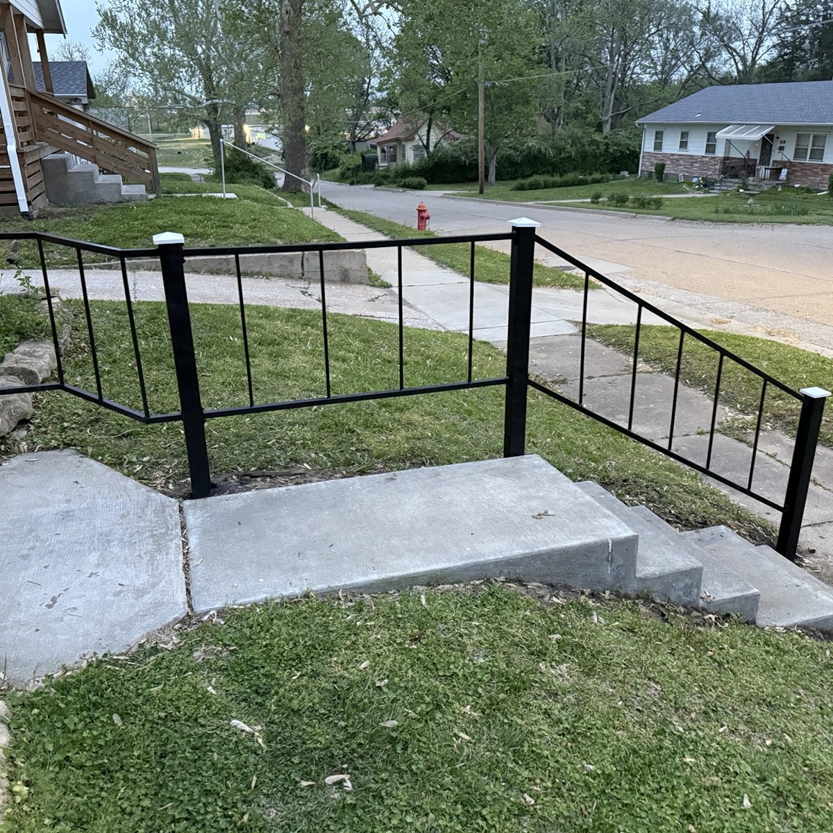 Black railings installed around concrete stairs and landing