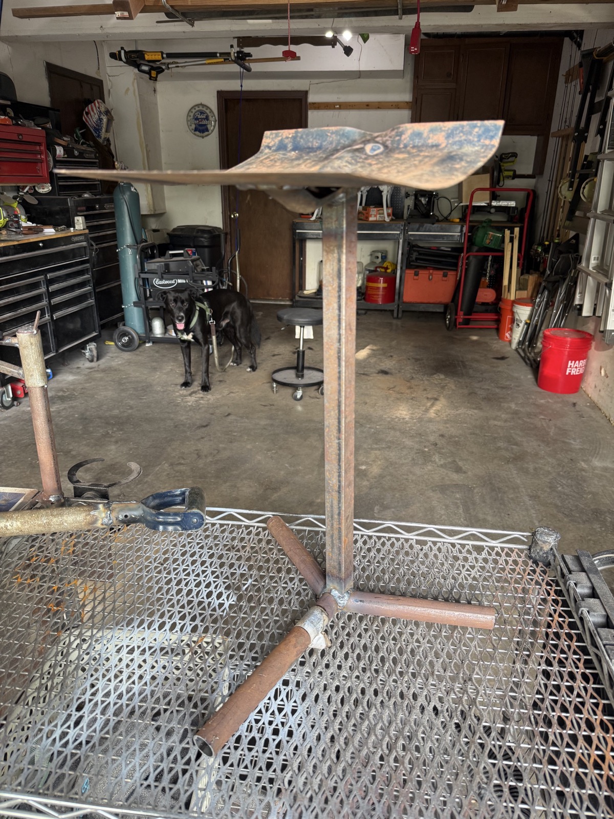 Close view of a welded steel scoop stand in a garage shop