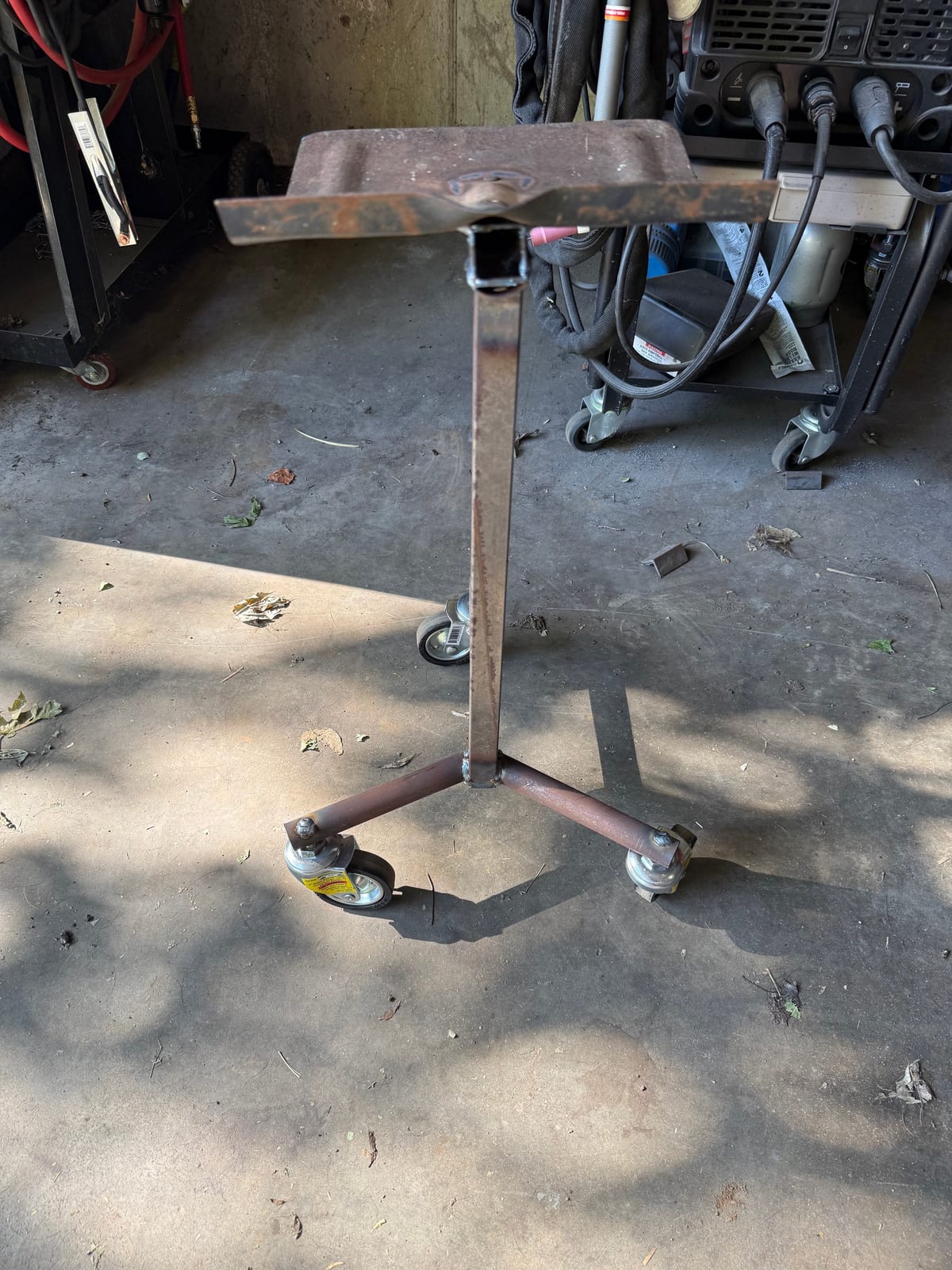 Front view of a welded steel stand with formed tray top and caster wheels